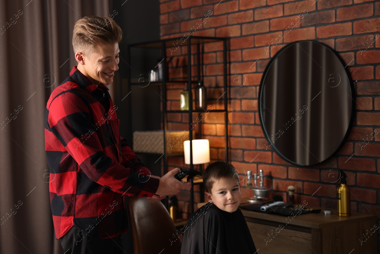 Professional barber working with little boy in barbershop Photo of Professional barber working with little boy in barbershop