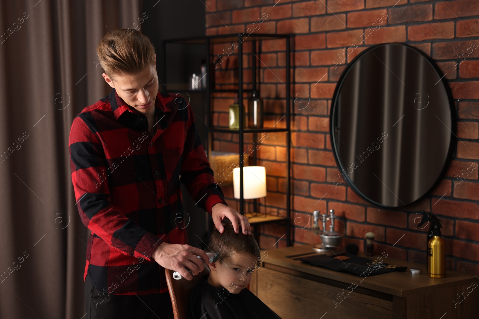 Professional barber working with little boy in barbershop Photo of Professional barber working with little boy in barbershop