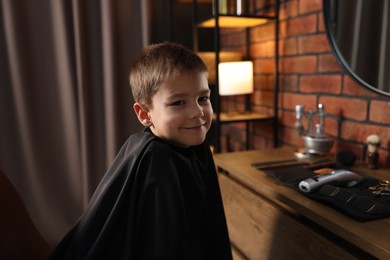 Photo of Portrait of cute little boy in barbershop