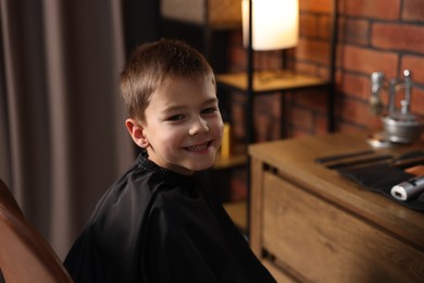 Photo of Portrait of cute little boy in barbershop