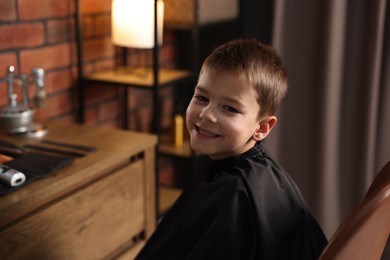 Photo of Portrait of cute little boy in barbershop