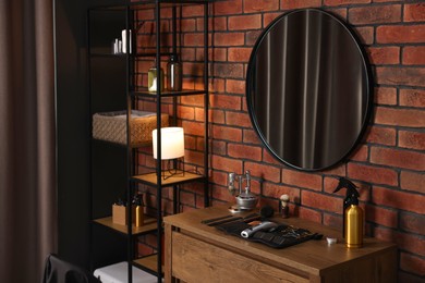 Photo of Different barber's tools on wooden cabinet and mirror in barbershop
