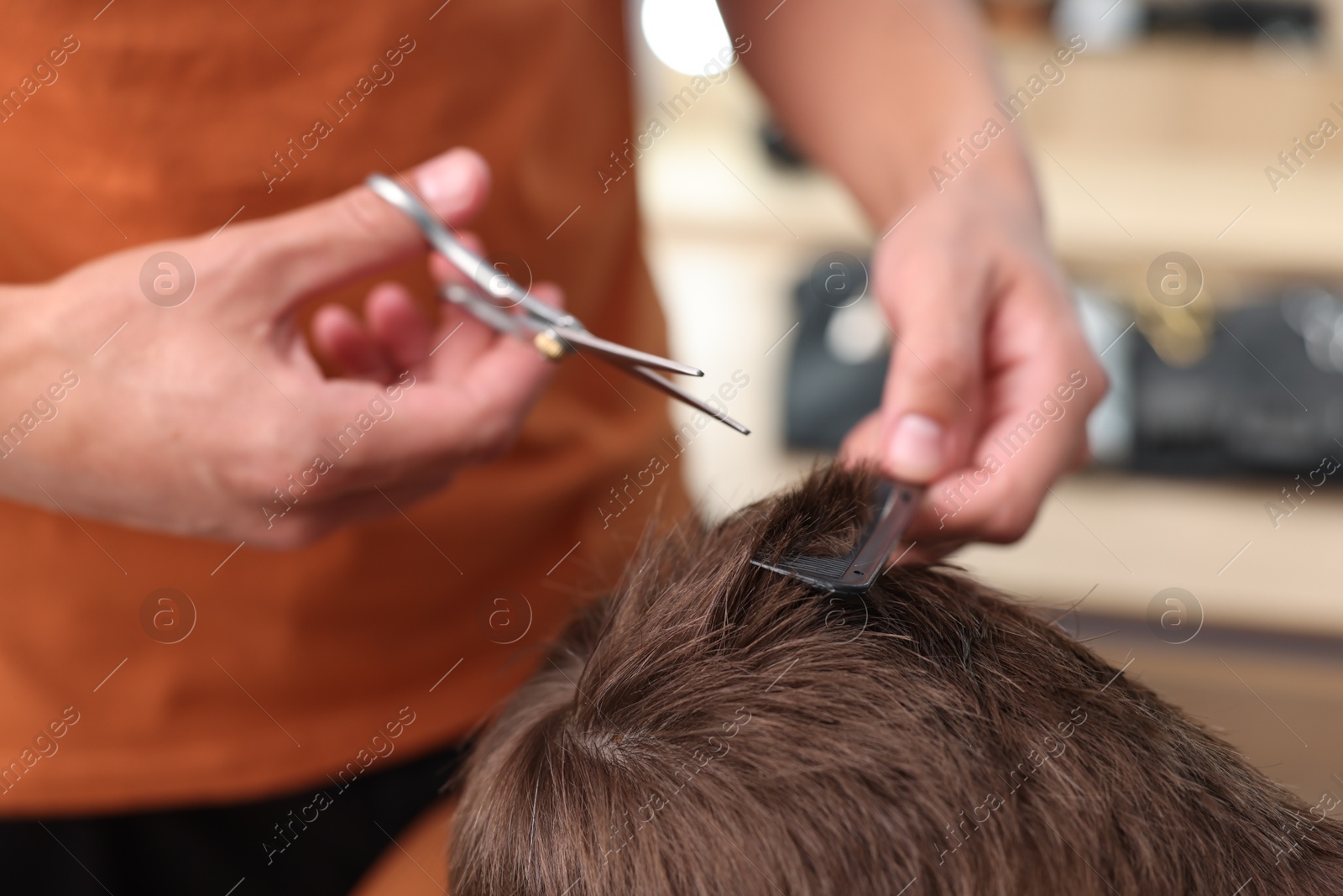 Professional barber cutting boy's hair in barbershop, closeup Photo of Professional barber cutting boy's hair in barbershop, closeup