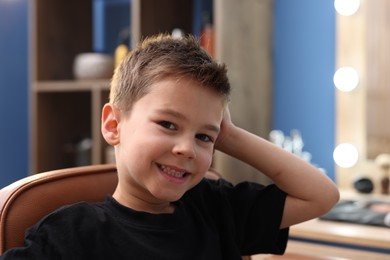 Photo of Portrait of cute little boy in barbershop