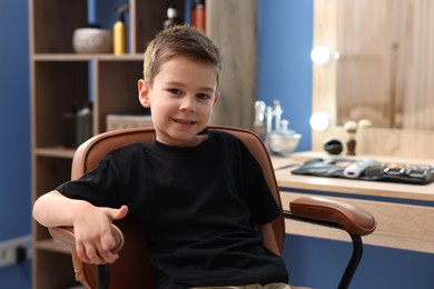 Photo of Portrait of cute little boy in barbershop