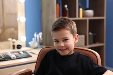 Photo of Portrait of cute little boy in barbershop
