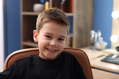 Photo of Portrait of cute little boy in barbershop