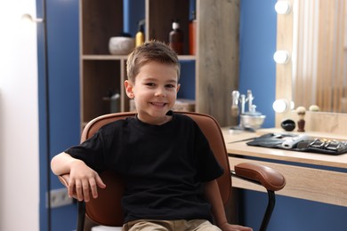Photo of Portrait of cute little boy in barbershop