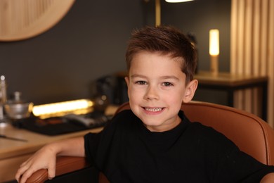 Photo of Portrait of cute little boy in barbershop