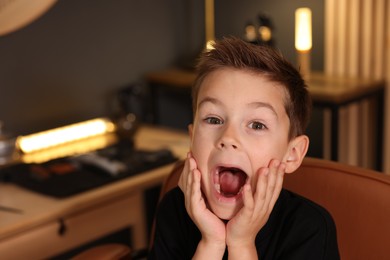 Photo of Portrait of cute little boy in barbershop, space for text