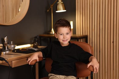 Photo of Portrait of cute little boy in barbershop