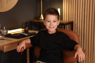 Photo of Portrait of cute little boy in barbershop