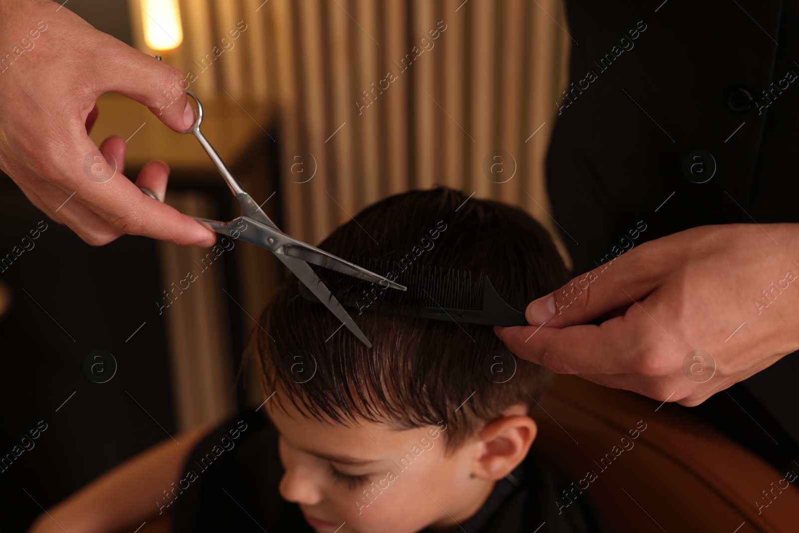 Professional barber cutting boy's hair in barbershop, closeup Photo of Professional barber cutting boy's hair in barbershop, closeup