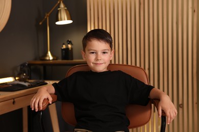 Photo of Cute little boy with wet hair in barbershop