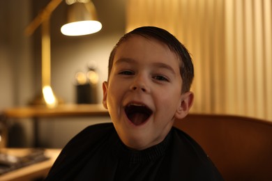 Photo of Portrait of cute little boy in barbershop