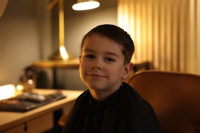 Photo of Portrait of cute little boy in barbershop
