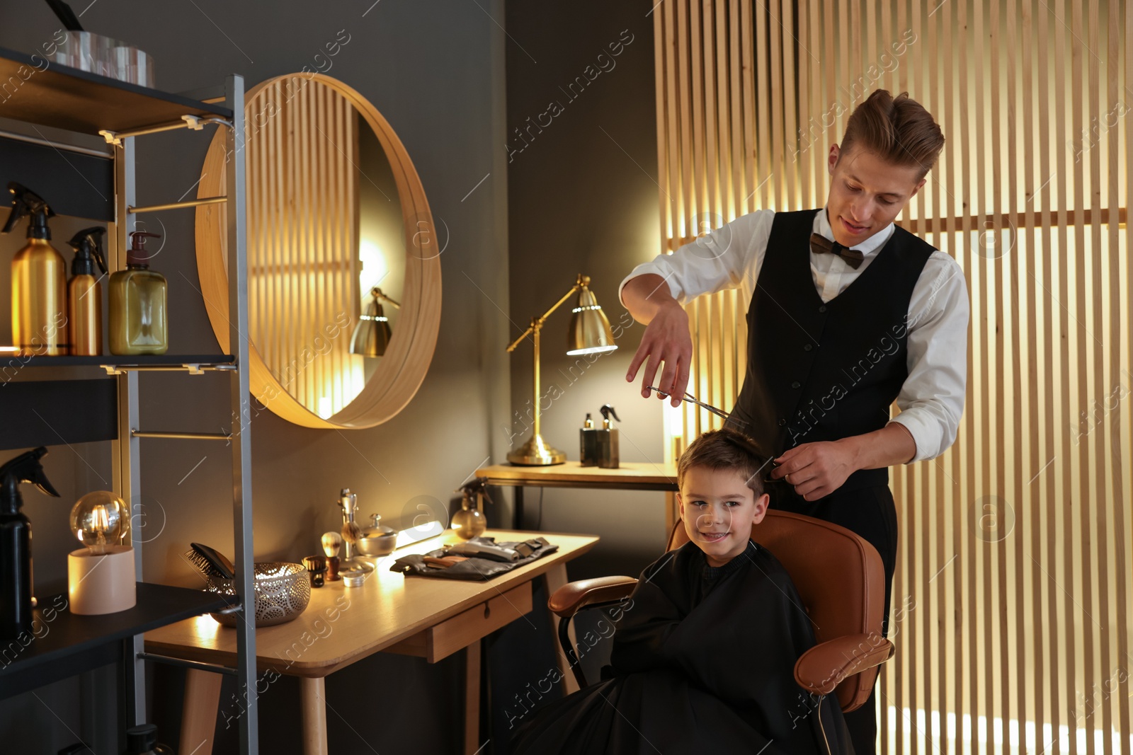 Professional barber cutting boy's hair in barbershop Photo of Professional barber cutting boy's hair in barbershop