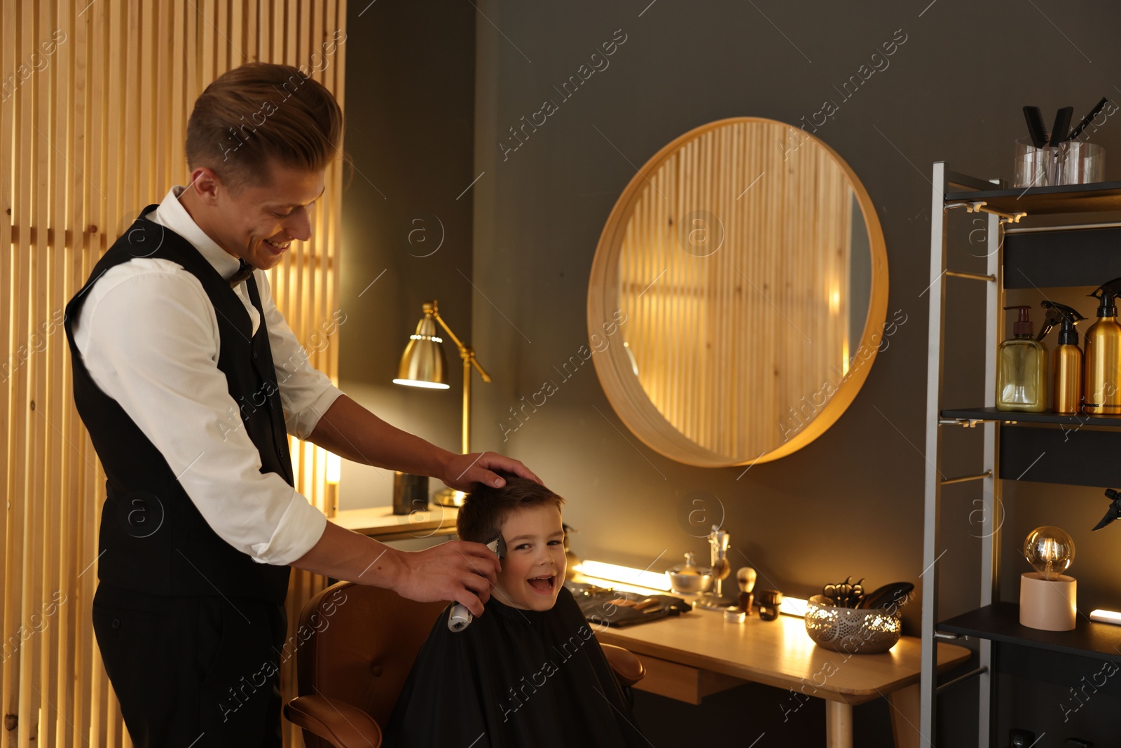Professional barber working with little boy in barbershop Photo of Professional barber working with little boy in barbershop