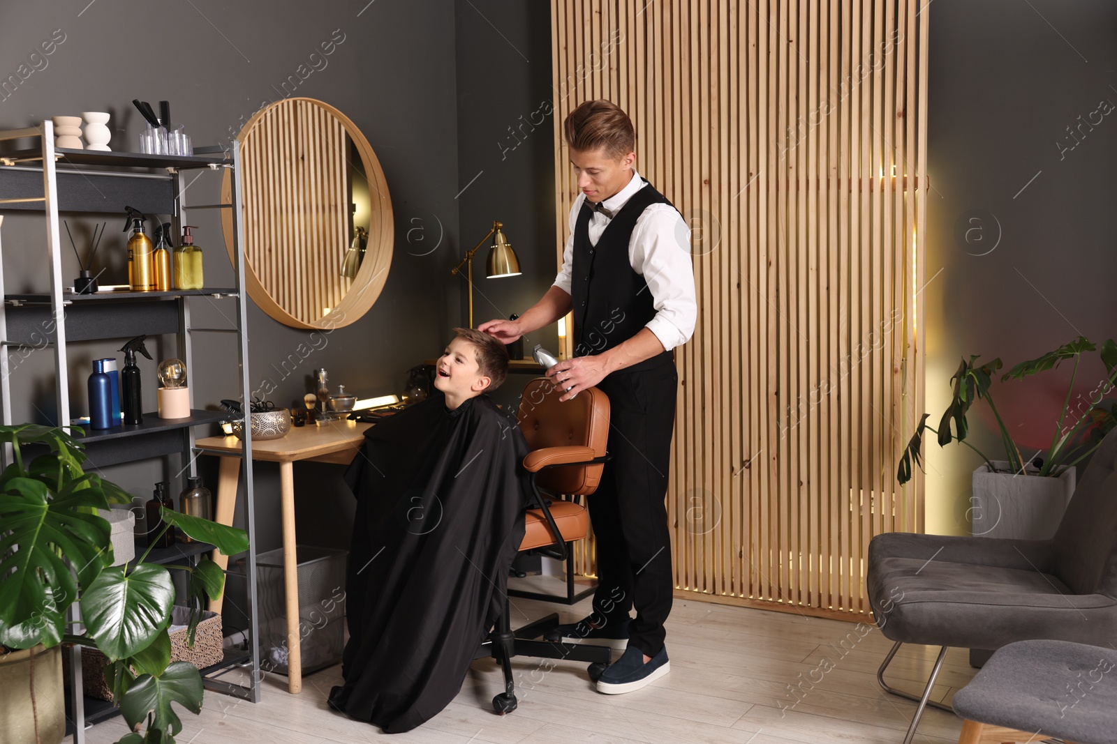 Professional barber working with little boy in barbershop Photo of Professional barber working with little boy in barbershop