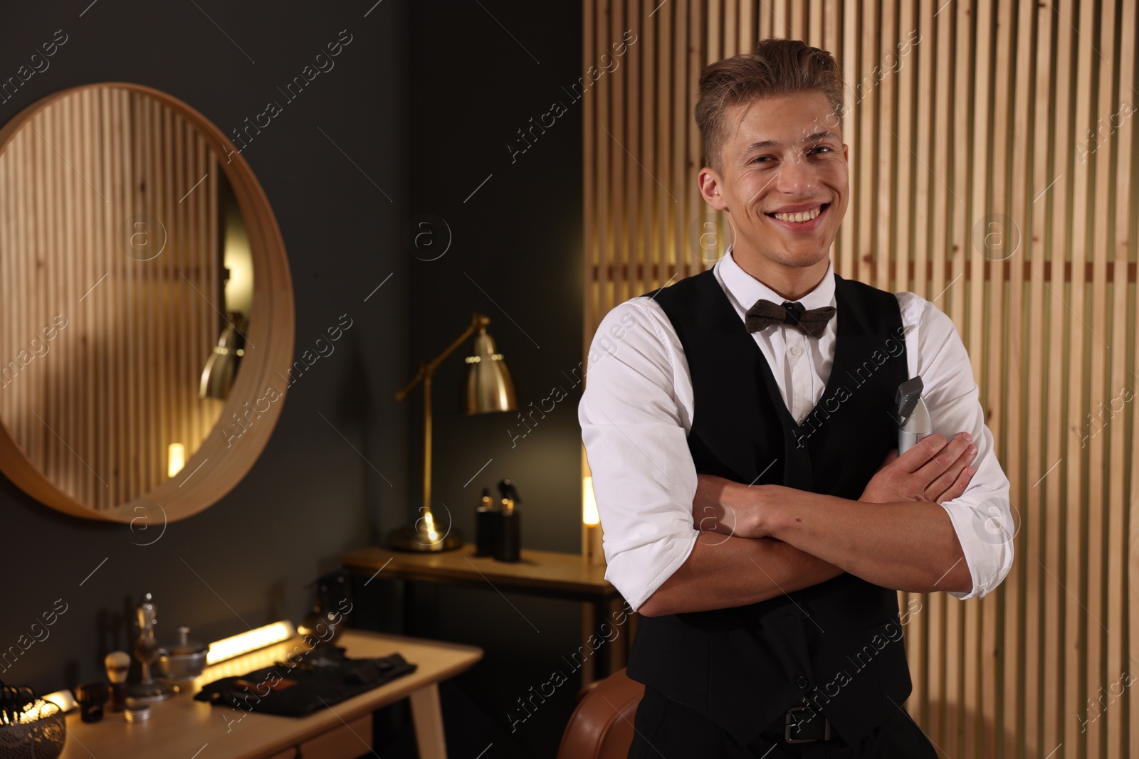 Happy professional barber with trimmer in barbershop, space for text Photo of Happy professional barber with trimmer in barbershop, space for text