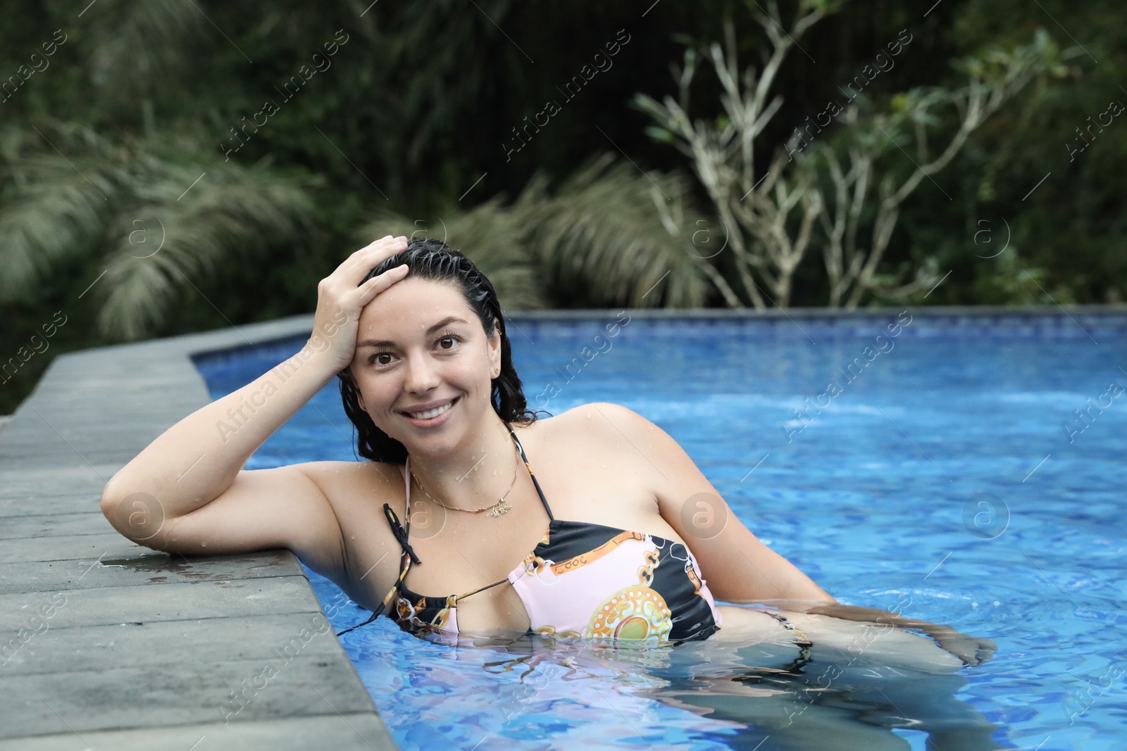 Happy woman relaxing in swimming pool outdoors Photo of Happy woman relaxing in swimming pool outdoors