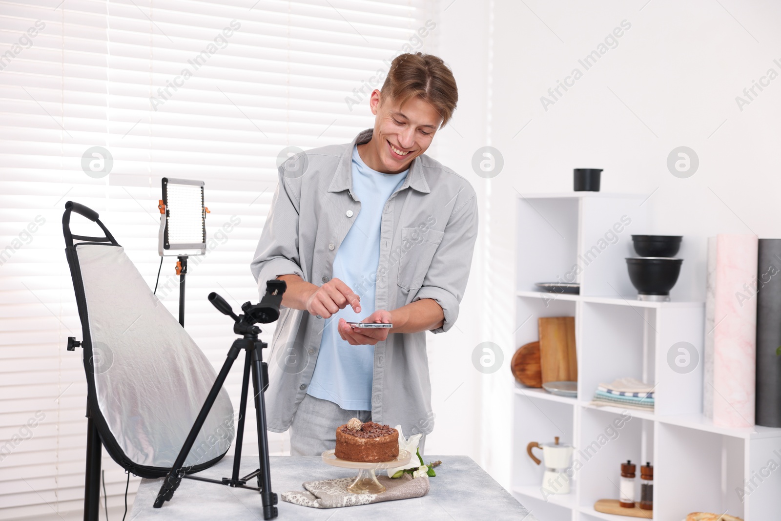 Man taking picture of chocolate cake in studio. Professional food photography Photo of Man taking picture of chocolate cake in studio. Professional food photography