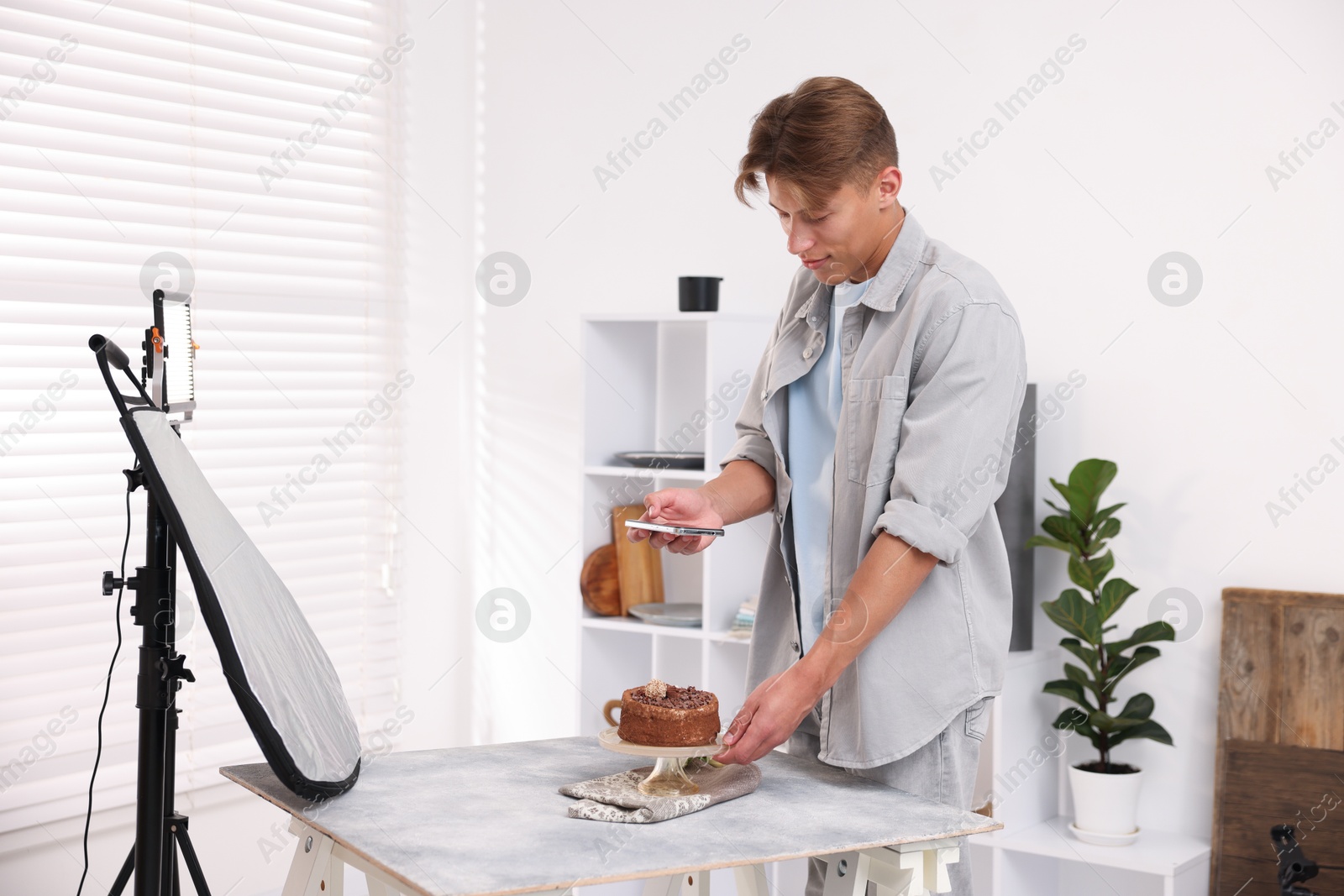 Man taking picture of chocolate cake in studio. Professional food photography Photo of Man taking picture of chocolate cake in studio. Professional food photography