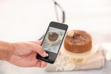 Photo of Man taking picture of chocolate cake in studio, selective focus. Professional food photography