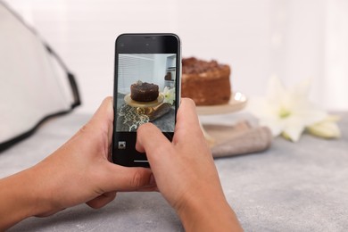 Photo of Man taking picture of chocolate cake in studio, selective focus. Professional food photography
