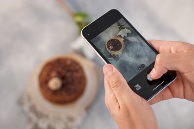 Photo of Man taking picture of chocolate cake in studio, above view. Professional food photography
