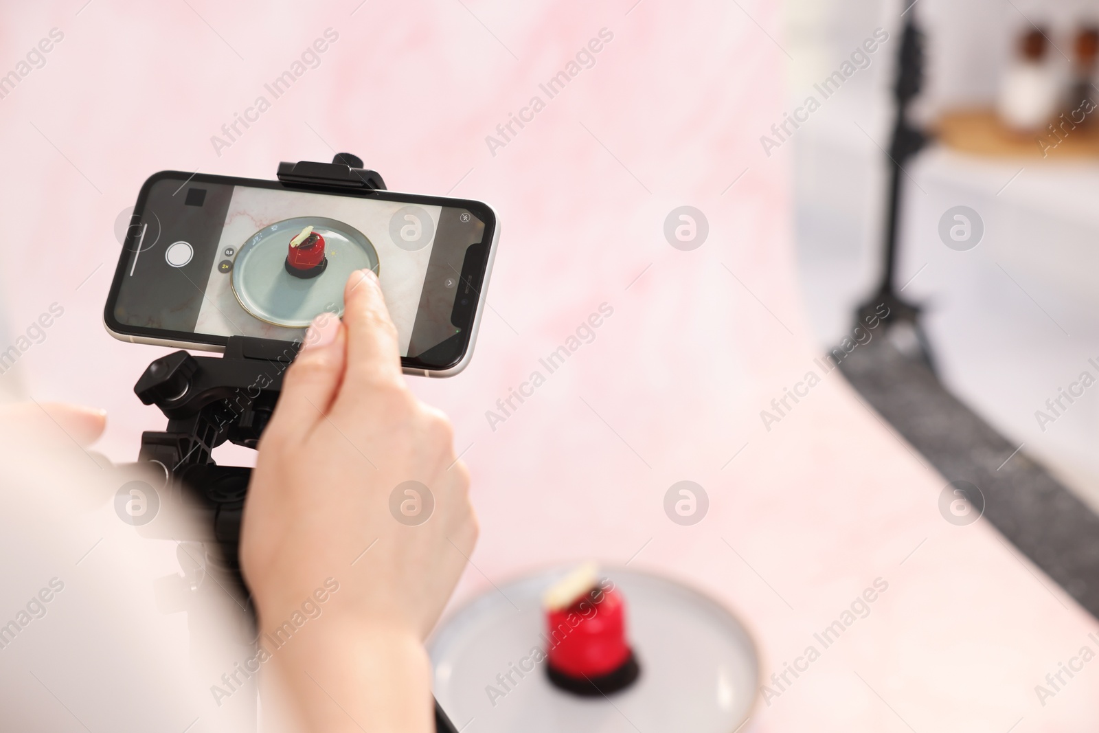 Photo of Woman taking picture of tasty dessert in studio, selective focus. Professional food photography