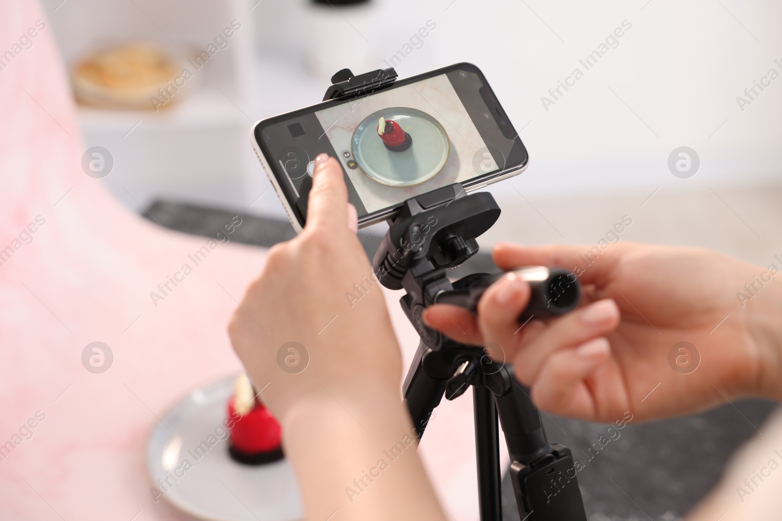 Photo of Woman taking picture of tasty dessert in studio, selective focus. Professional food photography