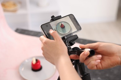 Photo of Woman taking picture of tasty dessert in studio, selective focus. Professional food photography