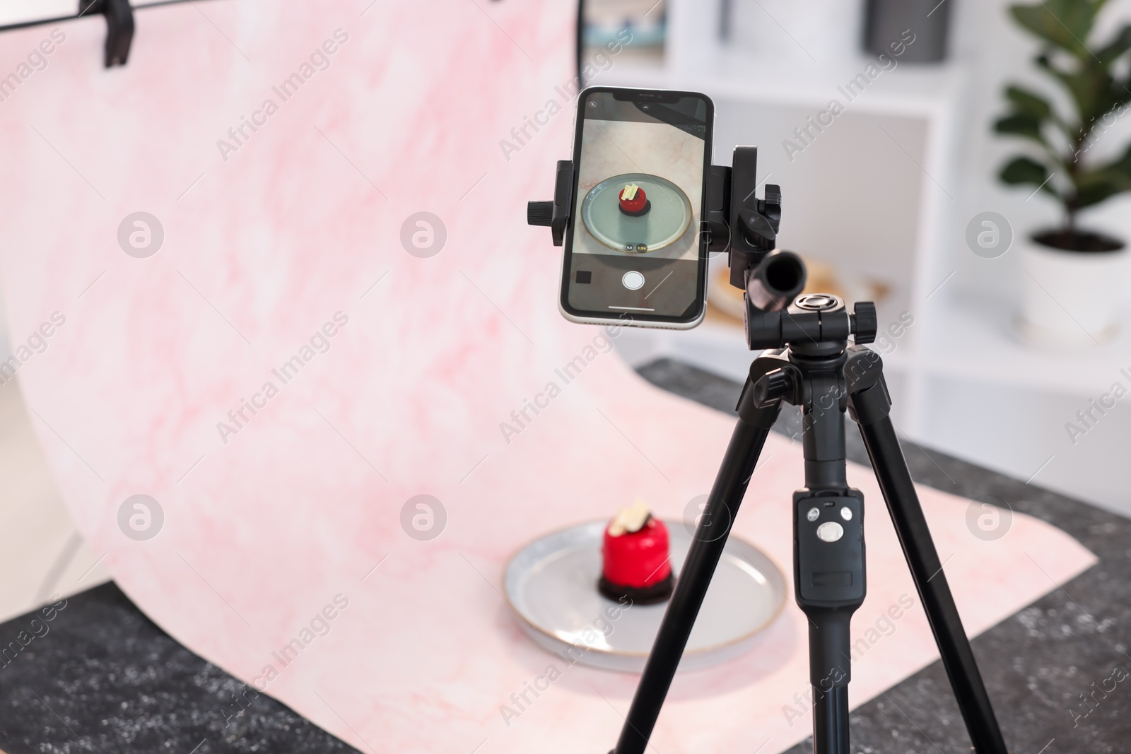 Photo of Shooting tasty dessert with smartphone in studio, selective focus. Professional food photography