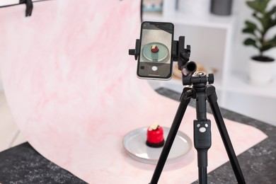 Photo of Shooting tasty dessert with smartphone in studio, selective focus. Professional food photography