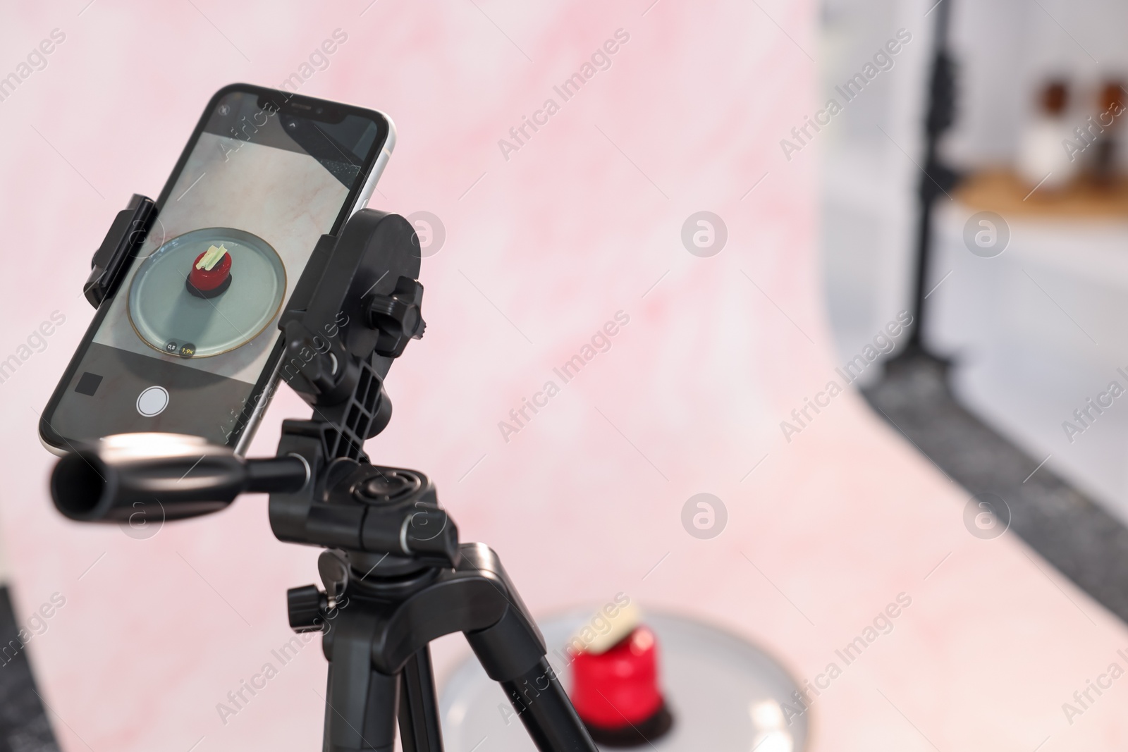 Photo of Shooting tasty dessert with smartphone in studio, selective focus. Professional food photography