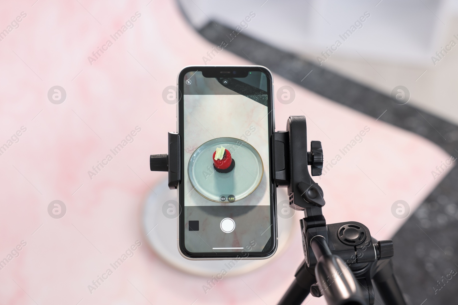 Photo of Shooting tasty dessert with smartphone in studio, above view. Professional food photography