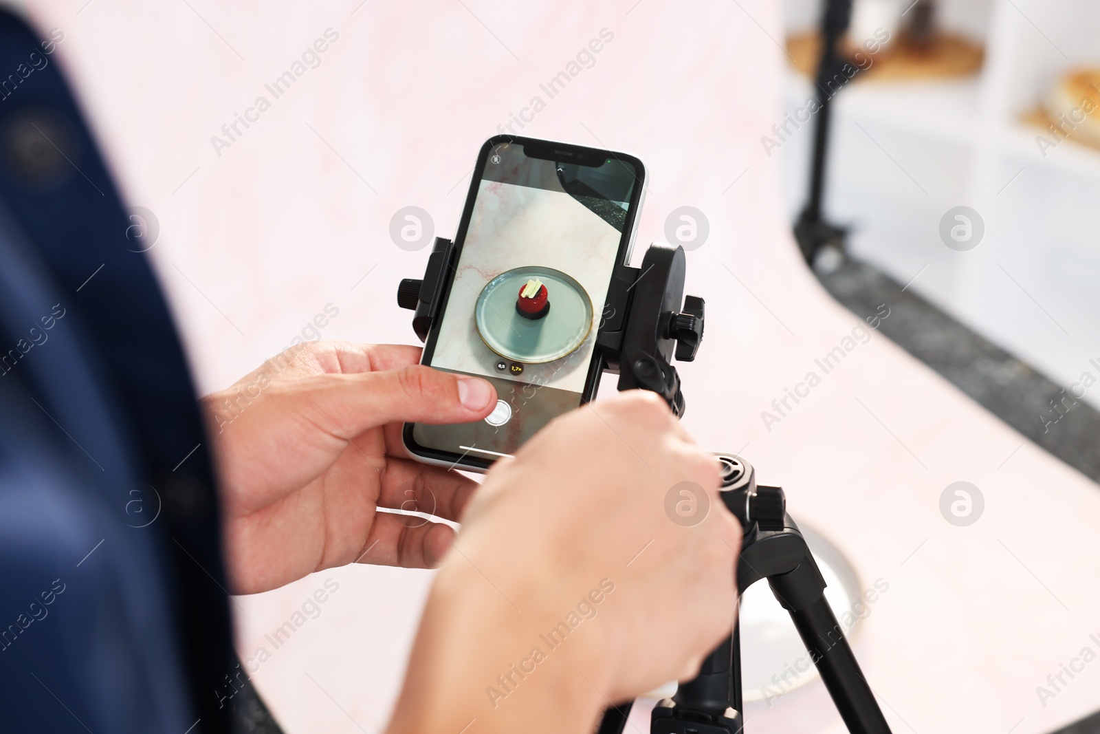 Photo of Man taking picture of tasty dessert in studio, selective focus. Professional food photography