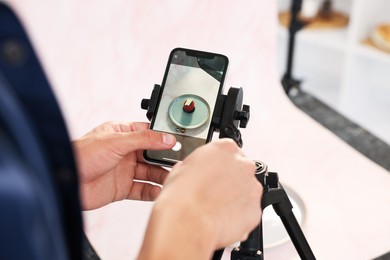 Photo of Man taking picture of tasty dessert in studio, selective focus. Professional food photography