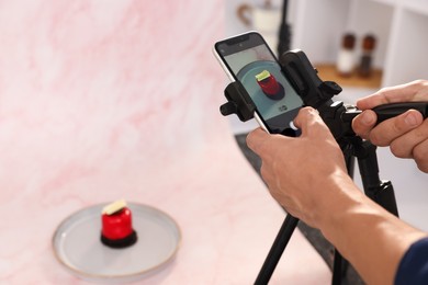 Photo of Man taking picture of tasty dessert in studio, selective focus. Professional food photography
