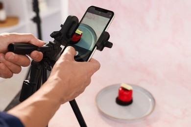 Photo of Man taking picture of tasty dessert in studio, selective focus. Professional food photography