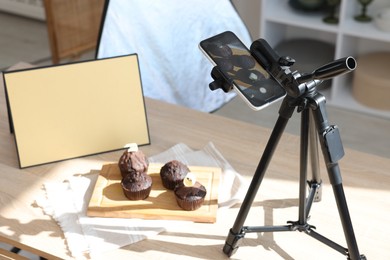 Photo of Shooting chocolate muffins with smartphone in studio. Professional food photography