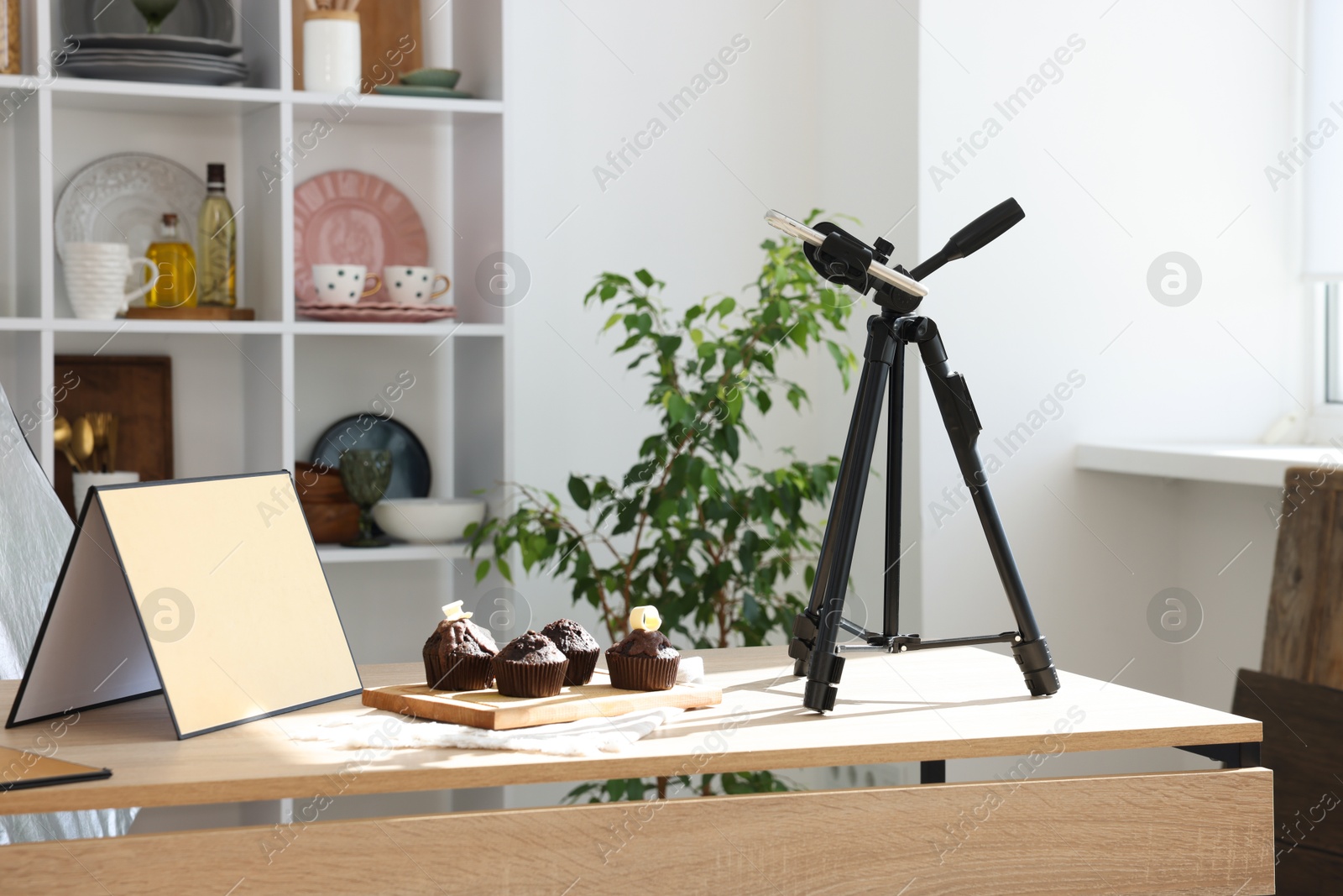 Photo of Shooting chocolate muffins with smartphone in studio. Professional food photography