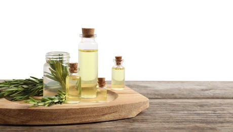 Photo of Bottles of essential oils and rosemary on wooden table against background