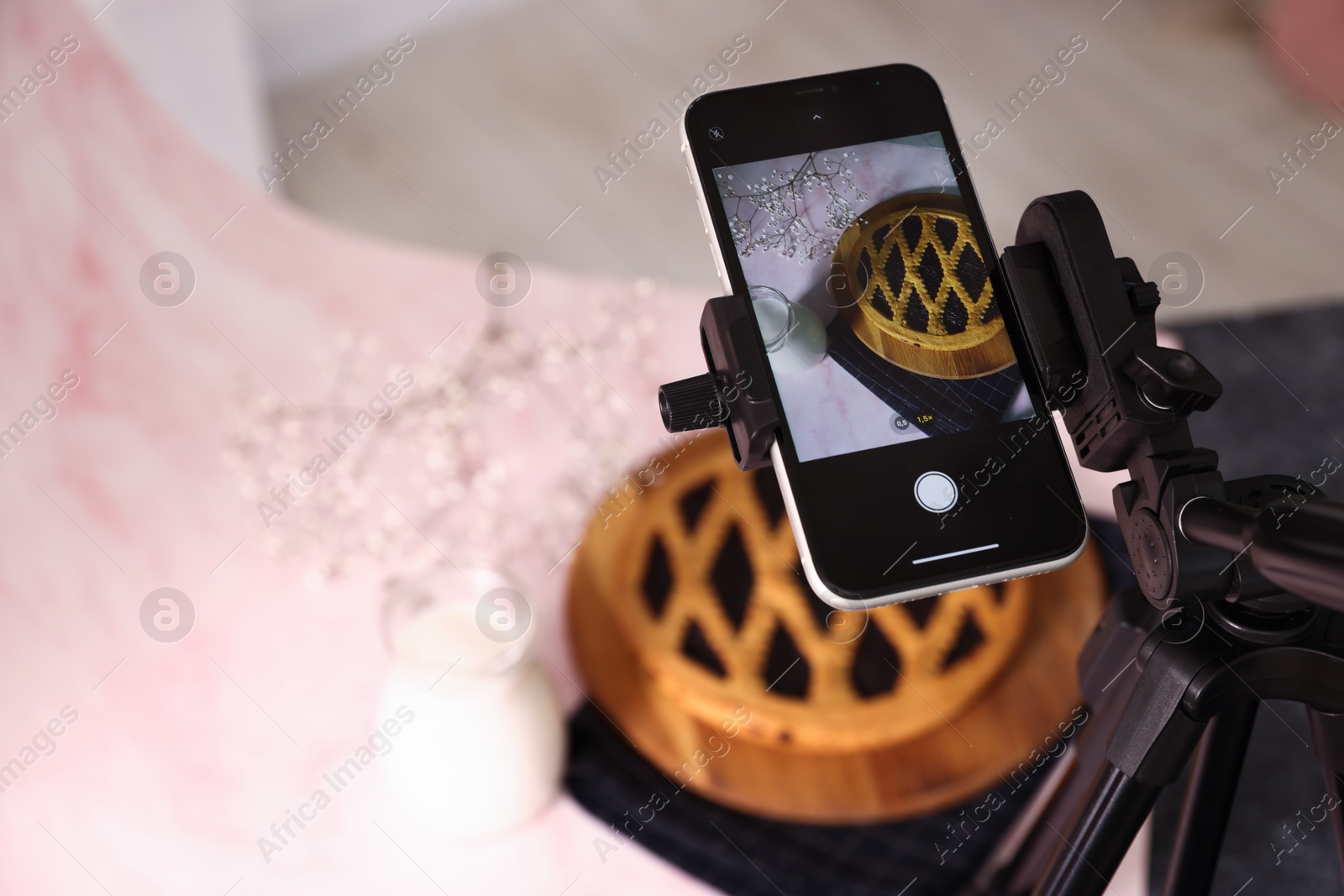 Photo of Shooting tasty pie and milk with smartphone in studio, above view. Professional food photography