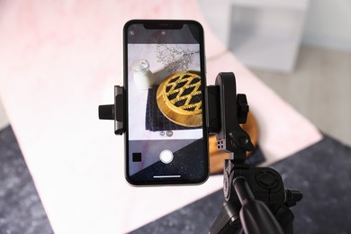 Photo of Shooting tasty pie and milk with smartphone in studio, above view. Professional food photography