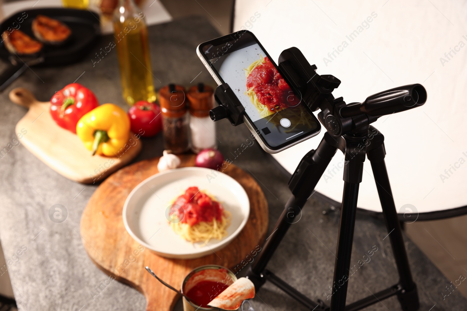 Photo of Shooting tasty pasta with smartphone in studio, selective focus. Professional food photography