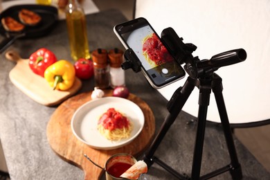Photo of Shooting tasty pasta with smartphone in studio, selective focus. Professional food photography