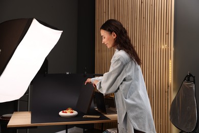 Photo of Woman creating composition with tasty pasta in studio. Professional food photography
