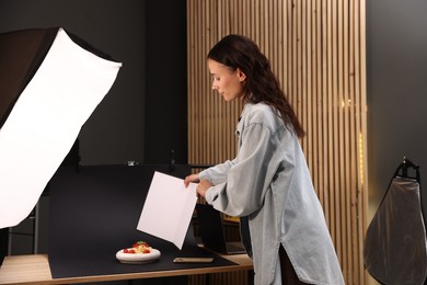 Photo of Woman creating composition with tasty pasta in studio. Professional food photography